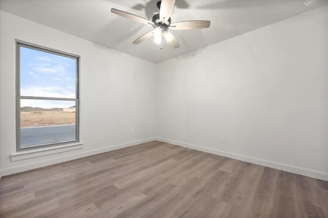 an empty room with a window and a fan