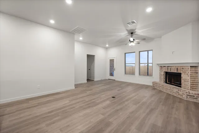 a view of an empty room with a fireplace and a window