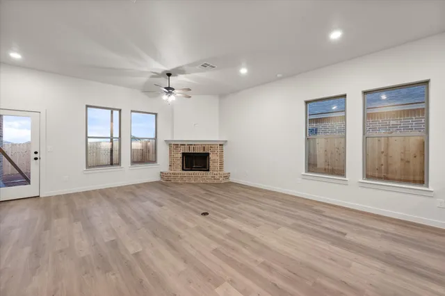 an empty room with windows and a fireplace