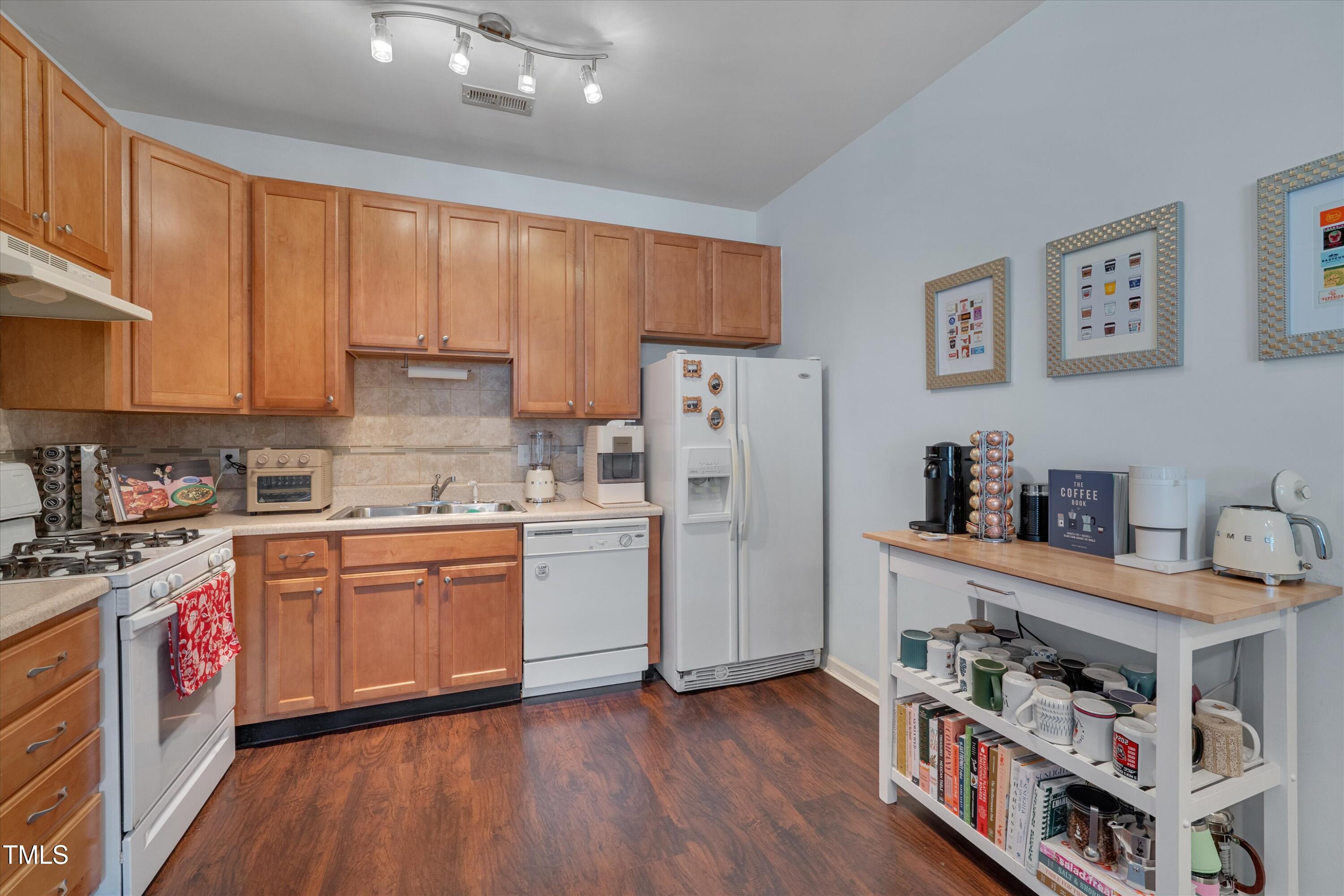 2210 Raven Road, Unit 106 Raleigh, NC 27614 - Photo 11 of 27 a kitchen with stainless steel appliances granite countertop a refrigerator a stove a sink dishwasher and white cabinets with wooden floor