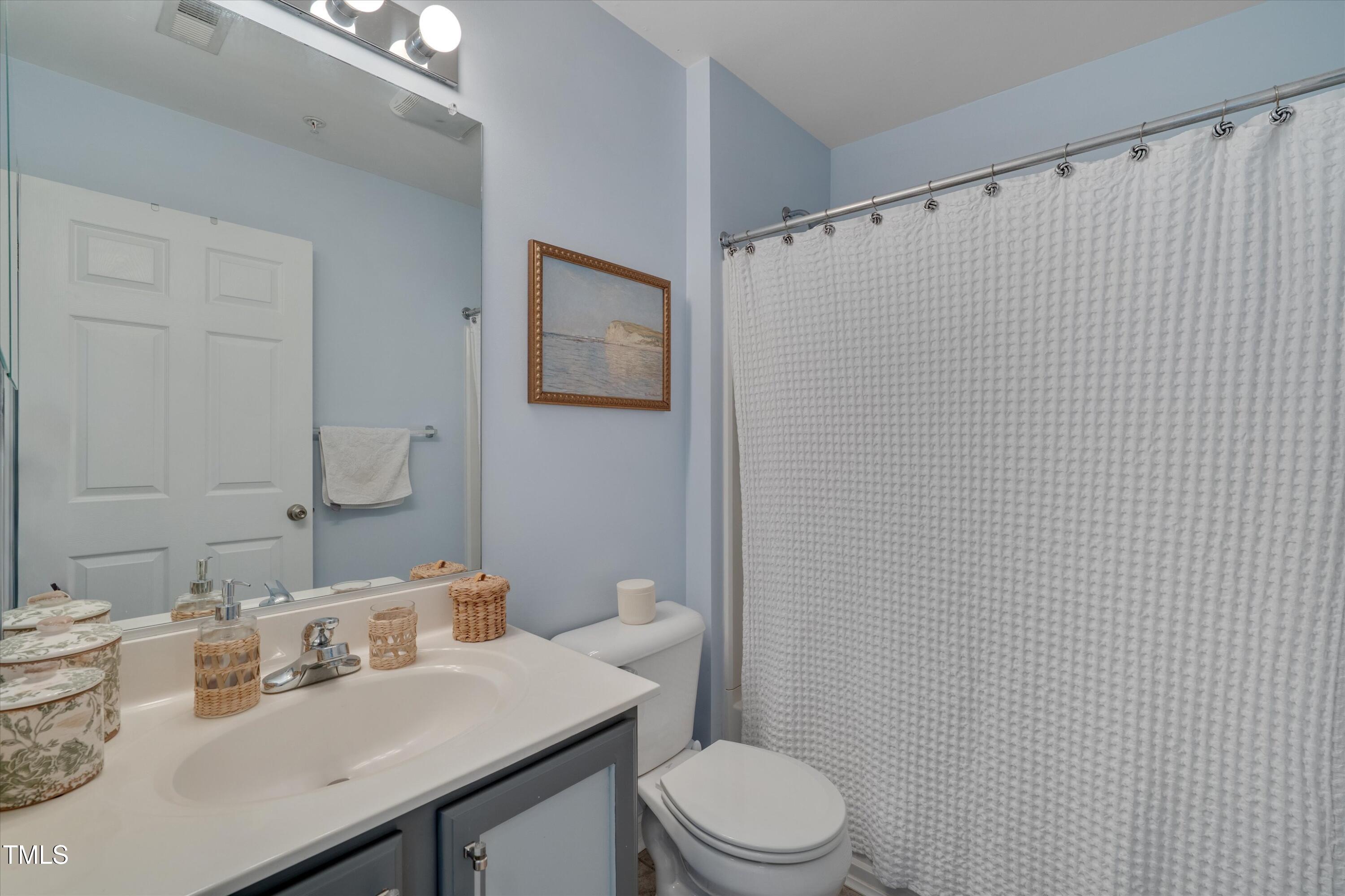2210 Raven Road, Unit 106 Raleigh, NC 27614 - Photo 17 of 27 a bathroom with a sink a toilet and shower curtain