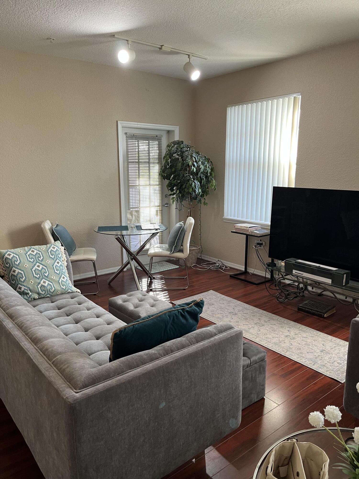 6890 West Sample Road, Unit 6890 Pompano Beach, FL 33063 - Photo 2 of 10 a living room with furniture and a flat screen tv