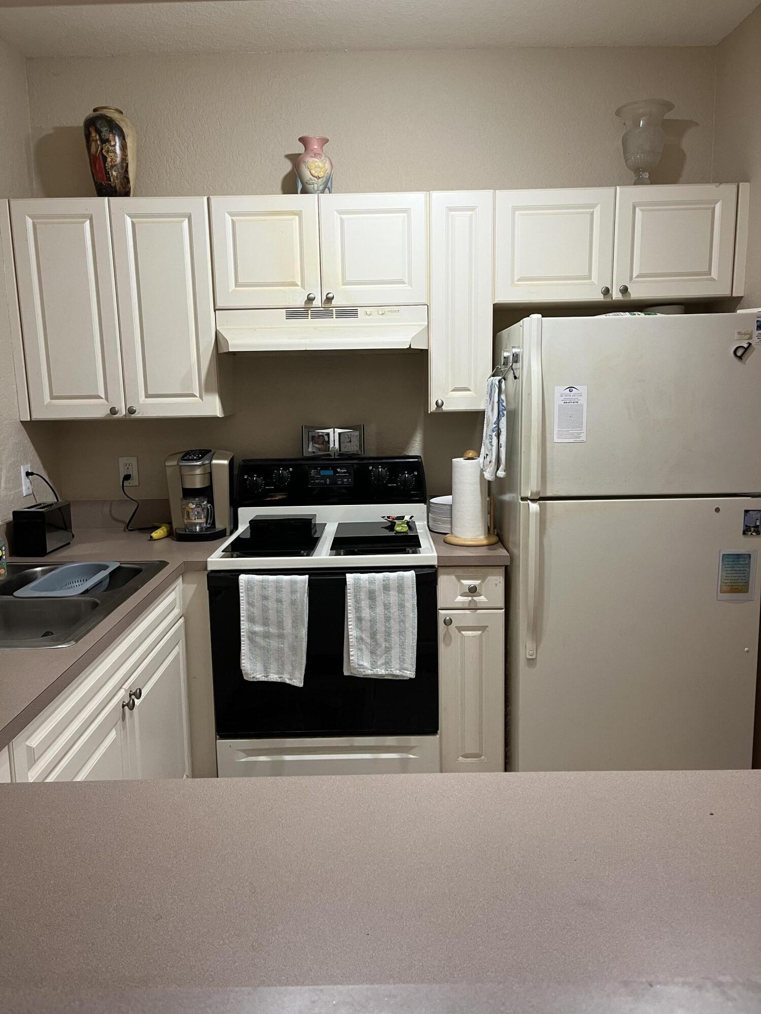 6890 West Sample Road, Unit 6890 Pompano Beach, FL 33063 - Photo 6 of 10 a kitchen with stainless steel appliances granite countertop a refrigerator a stove a sink and a refrigerator