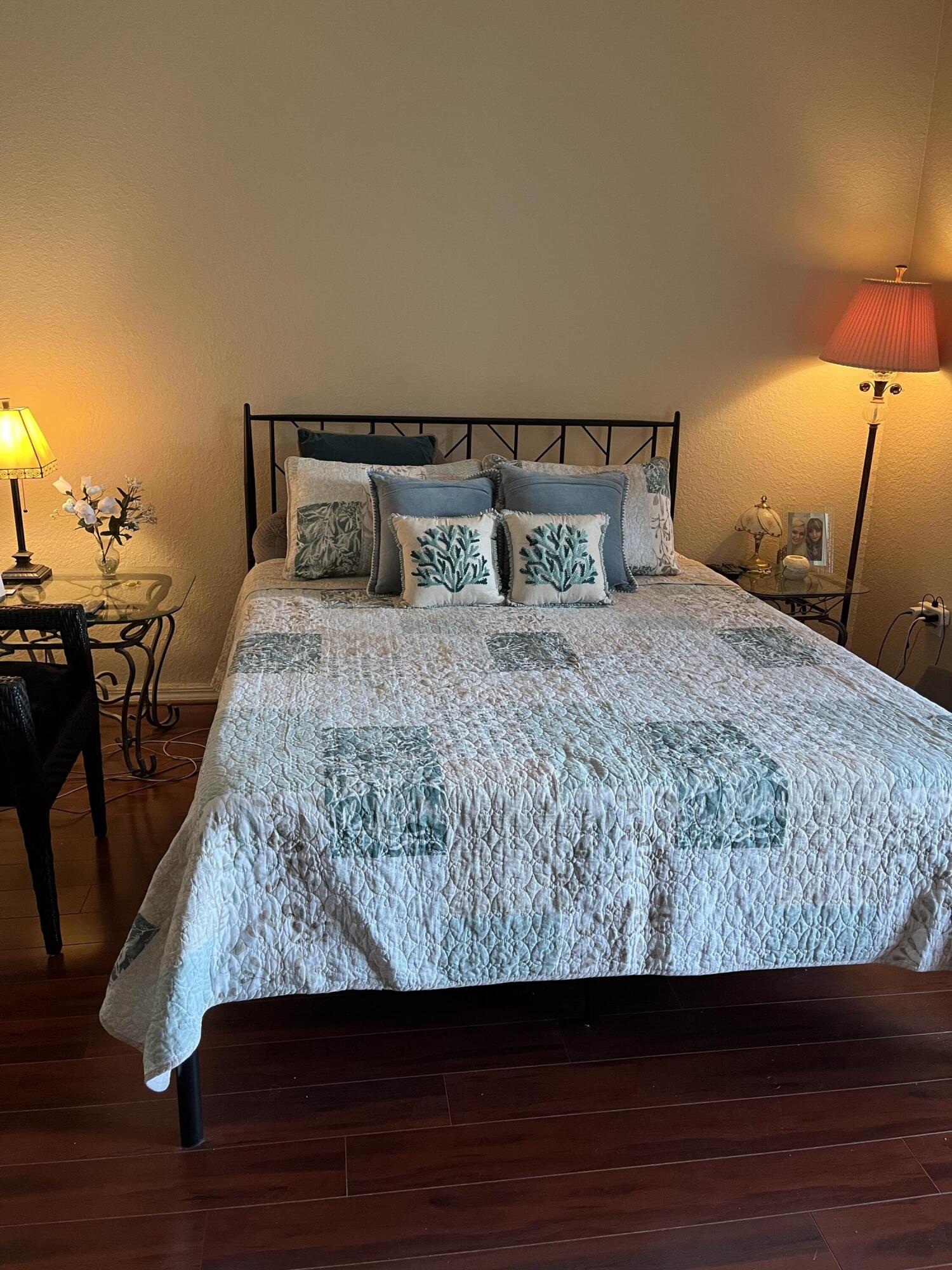 6890 West Sample Road, Unit 6890 Pompano Beach, FL 33063 - Photo 8 of 10 a bedroom with a bed and wooden floor