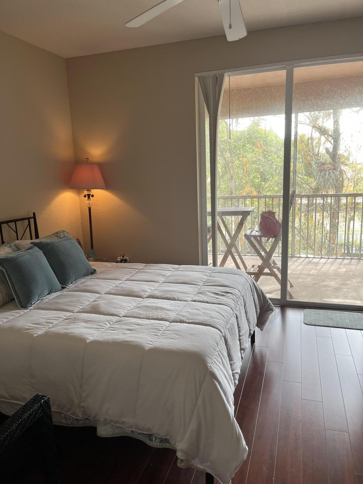 6890 West Sample Road, Unit 6890 Pompano Beach, FL 33063 - Photo 9 of 10 a bedroom with a bed and a large window