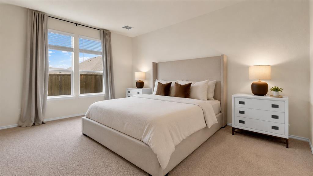 707 Indigo Road Princeton, TX 75407 - Photo 16 of 29 Spacious bedroom featuring light-colored carpet, large windows with blinds and drapery rods, and neutral wall tones