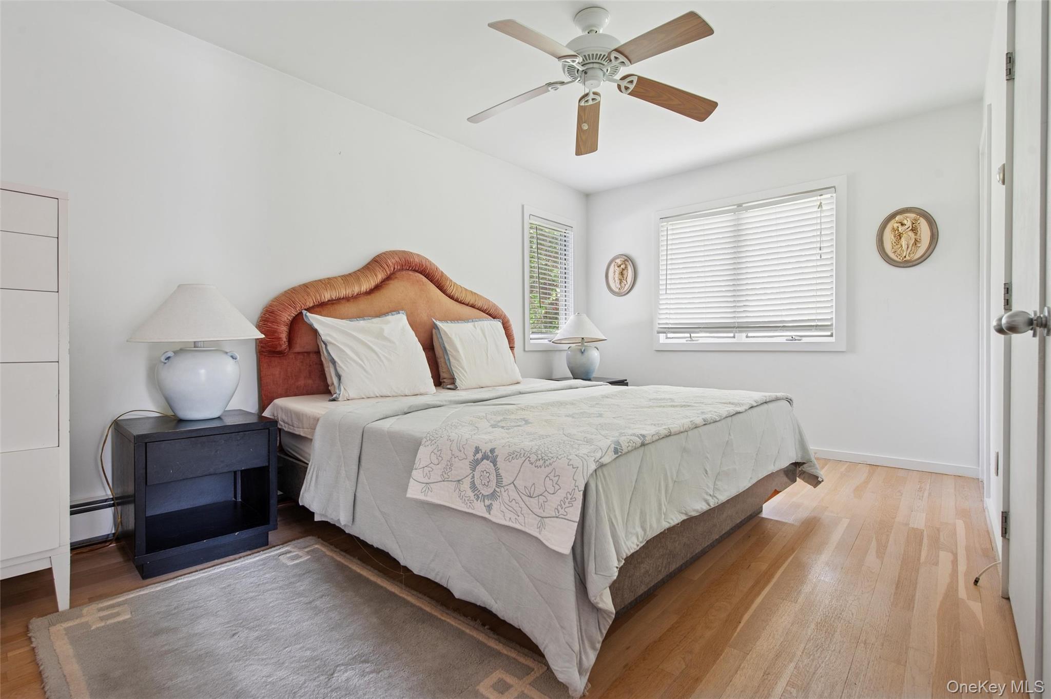 251 Sebonac Road Southampton, NY 11968 - Photo 8 of 15 a bedroom with a bed and a chandelier