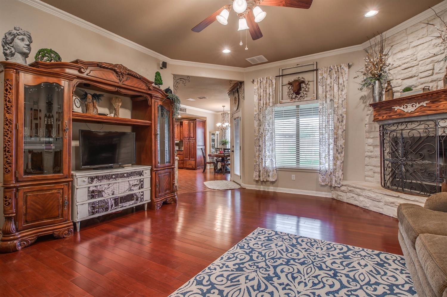 5518 104th Street Lubbock, TX 79424 - Photo 8 of 10 a view of a livingroom with furniture wooden floor and a fireplace