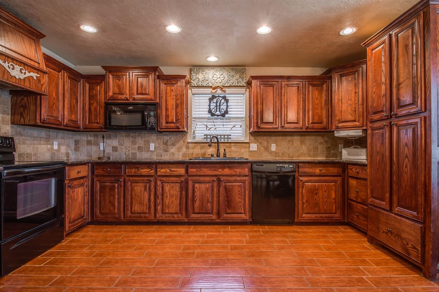 5518 104th Street Lubbock, TX 79424 - Photo 10 of 10 a kitchen with stainless steel appliances granite countertop wooden cabinets a stove top oven a granite counter tops and a window
