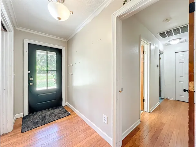 a kitchen with stainless steel appliances granite countertop a refrigerator a stove top oven a sink dishwasher and white cabinets with wooden floor