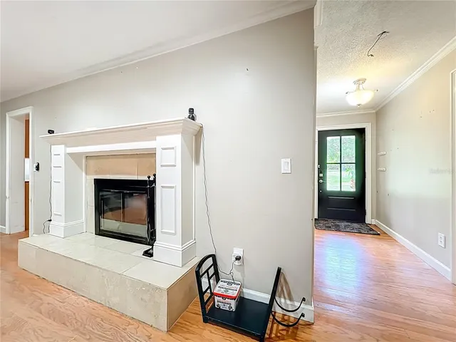 an empty room with wooden floor cabinet and windows