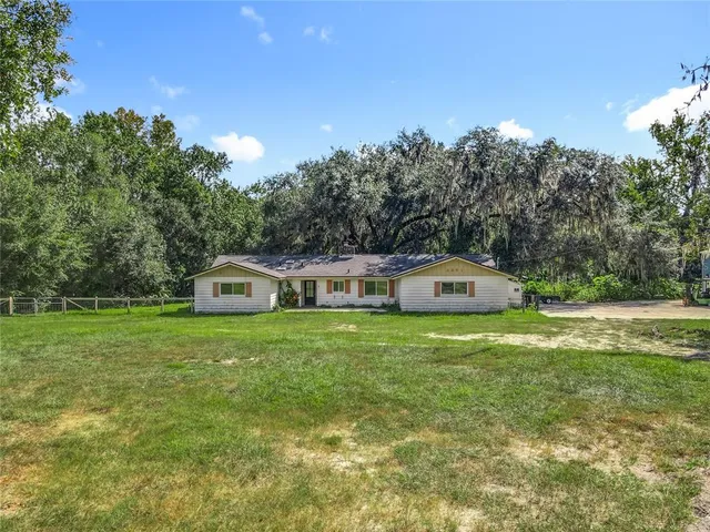 a view of a house with a swimming pool and a yard