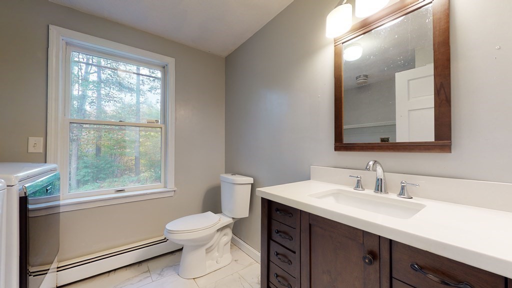 7 Nehemiah Road Shirley, MA 01464 - Photo 22 of 37 a bathroom with a toilet a sink a window and mirror