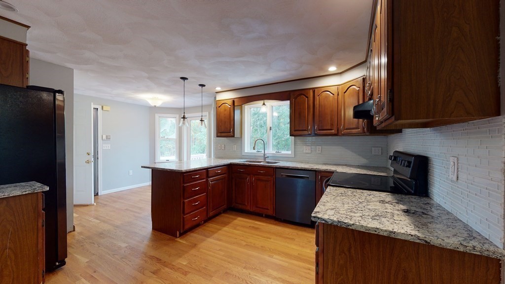 7 Nehemiah Road Shirley, MA 01464 - Photo 8 of 37 a kitchen with stainless steel appliances granite countertop wooden cabinets a refrigerator and a sink