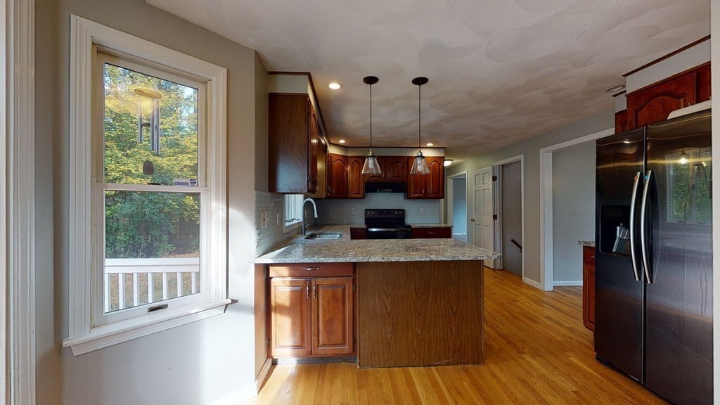 7 Nehemiah Road Shirley, MA 01464 - Photo 9 of 37 a kitchen with granite countertop a refrigerator a stove a sink and dishwasher with wooden floor