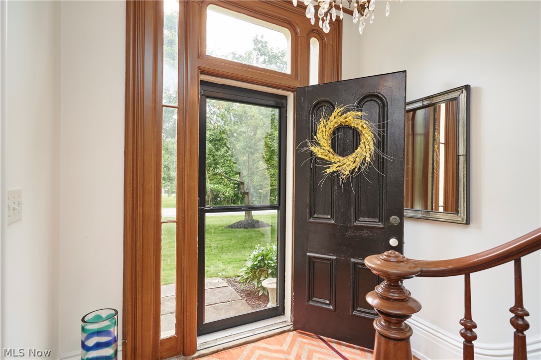 5046 Alger Road Richfield, OH 44286 - Photo 10 of 49 Entryway featuring a dark paneled door, a storm door with exterior views, and a sidelight with an arched transom