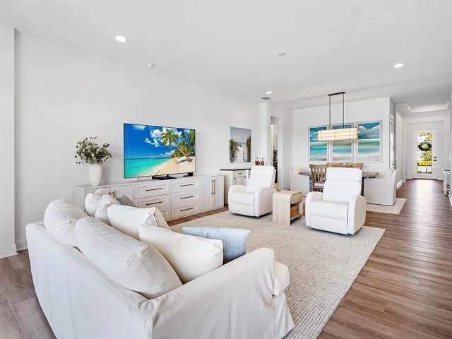 a kitchen with stainless steel appliances granite countertop a microwave a stove a sink dishwasher a refrigerator white cabinets and wooden floor