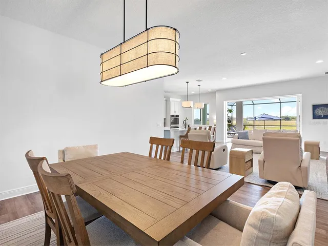 a kitchen with stove a sink and white cabinets with wooden floor