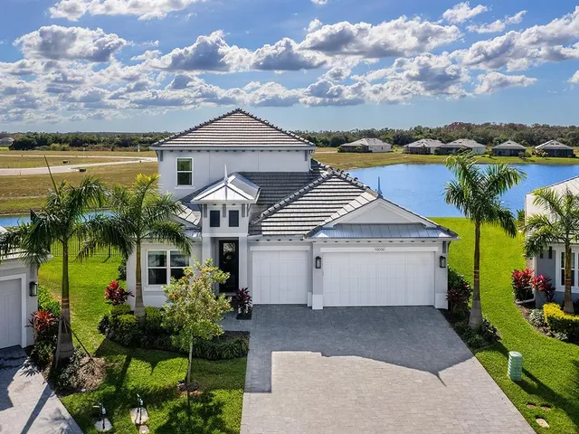 a view of a house with a yard and potted plants