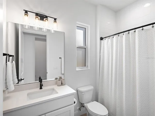 a living room with patio furniture and a potted plant