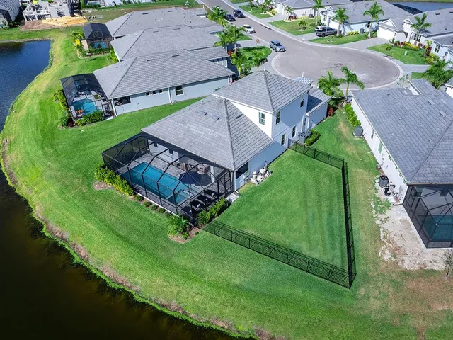 a view of a house with a big yard couches and palm trees