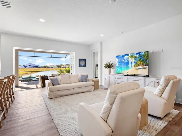 a dining room with furniture a chandelier and wooden floor