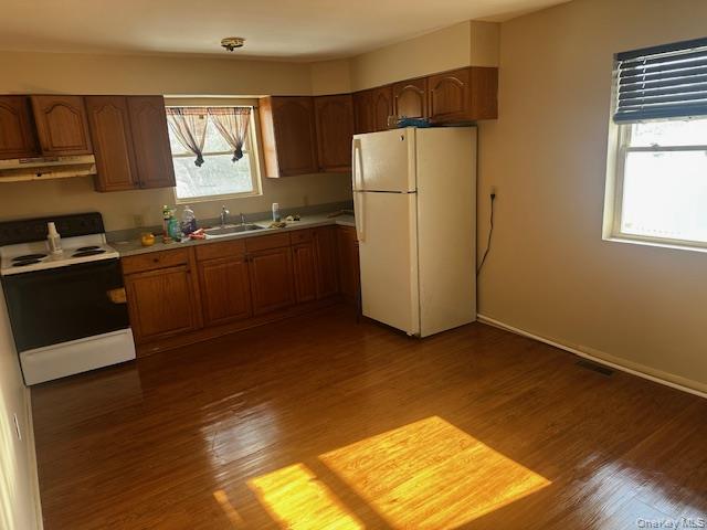 542 Post Avenue Bellport, NY 11713 - Photo 11 of 38 a kitchen with refrigerator a window and wooden cabinets