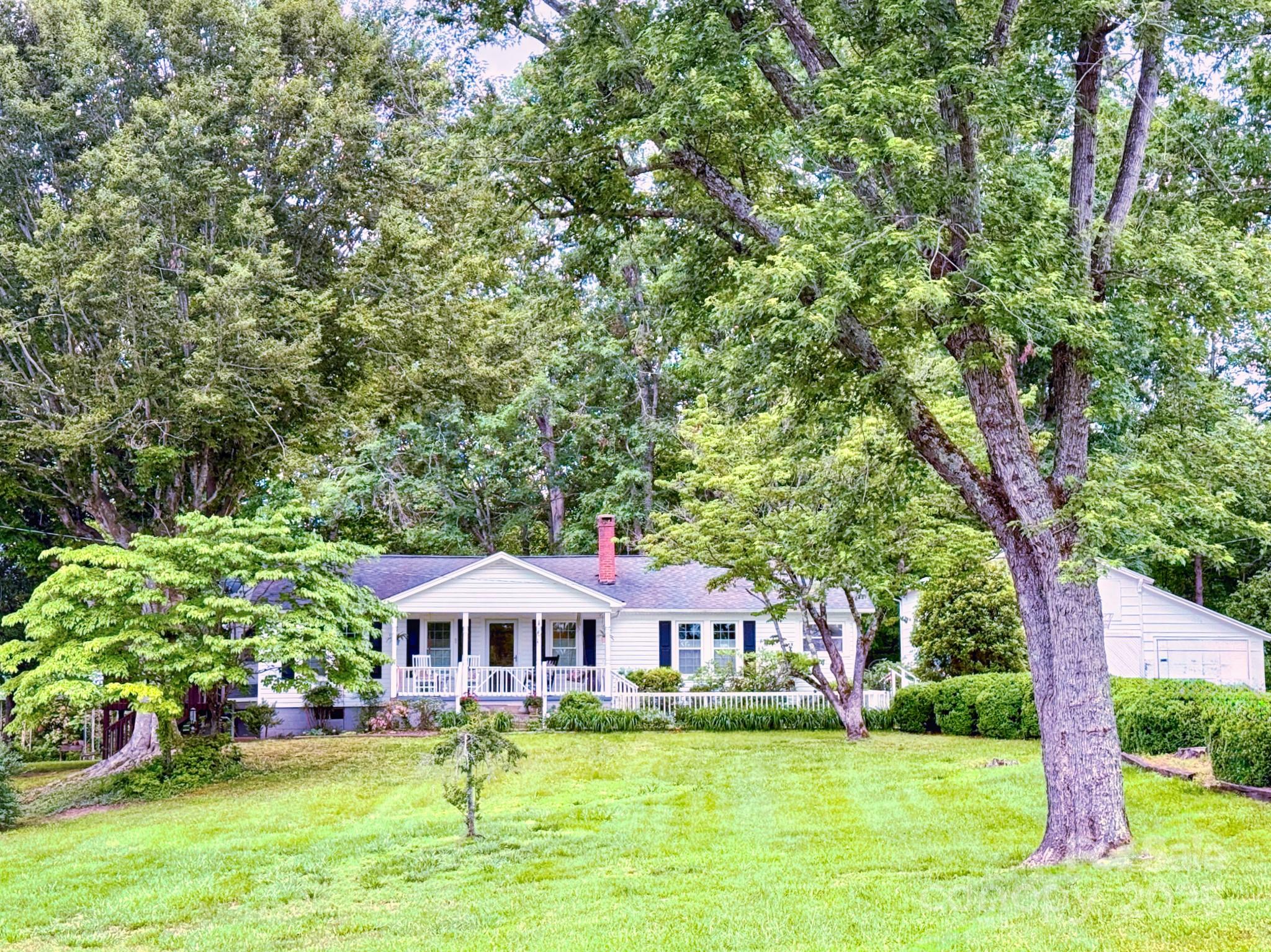1441 Cove Road Rutherfordton, NC 28139 - Photo 1 of 36 a front view of a house with a garden and trees