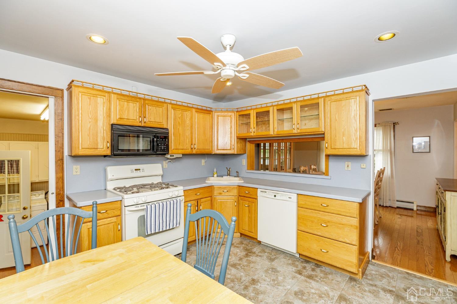55 Old Post Road Edison, NJ 08817 - Photo 12 of 53 a kitchen with stainless steel appliances kitchen island granite countertop a stove top oven a sink dishwasher and white cabinets with wooden floor