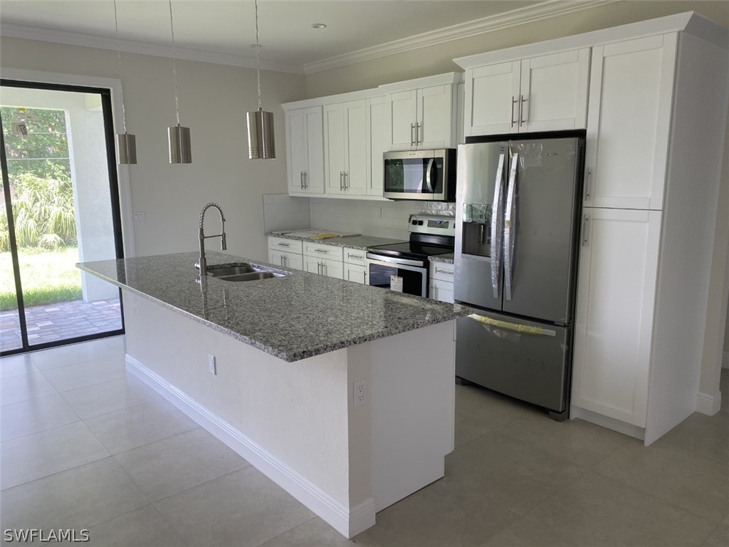 7337 Lobelia Road Fort Myers, FL 33967 - Photo 12 of 21 a kitchen with stainless steel appliances granite countertop a refrigerator a stove a sink a microwave and a refrigerator