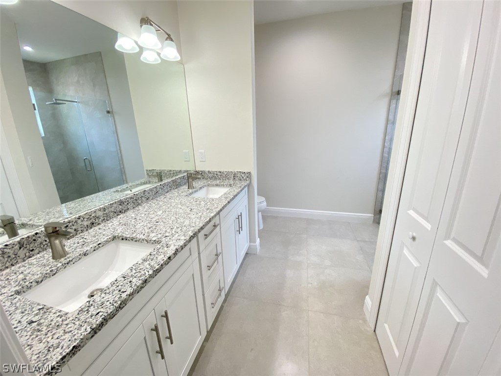 7337 Lobelia Road Fort Myers, FL 33967 - Photo 16 of 21 a bathroom with a granite countertop sink a mirror and a shower