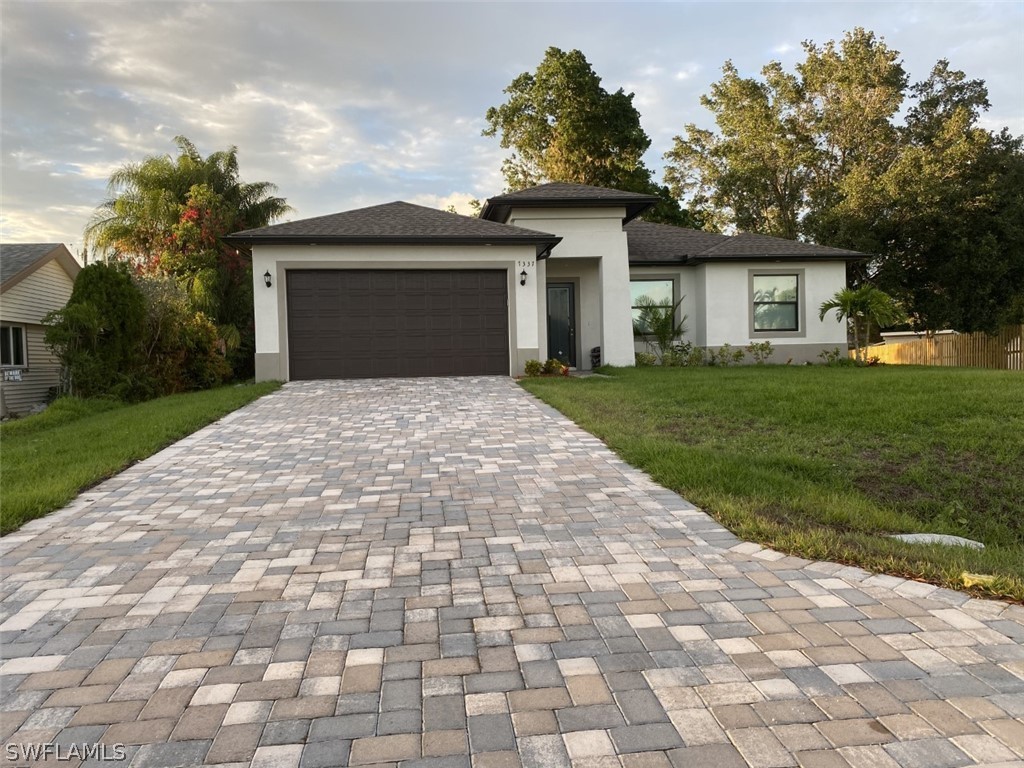 7337 Lobelia Road Fort Myers, FL 33967 - Photo 2 of 21 a front view of a house with a yard and garage