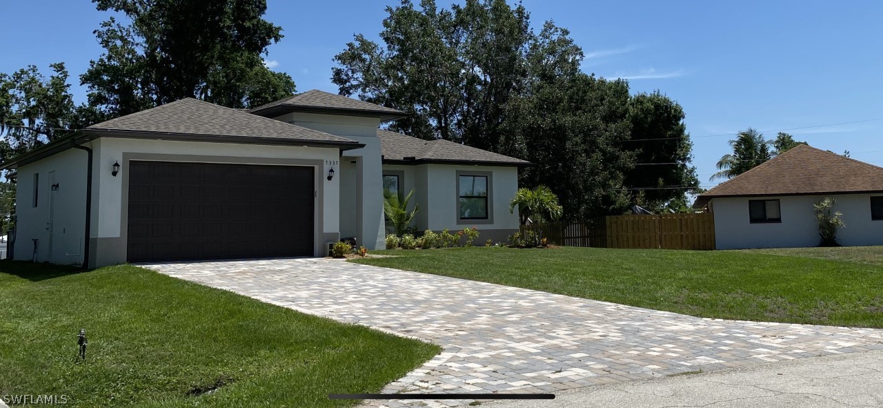 7337 Lobelia Road Fort Myers, FL 33967 - Photo 3 of 21 a front view of a house with a yard and garage