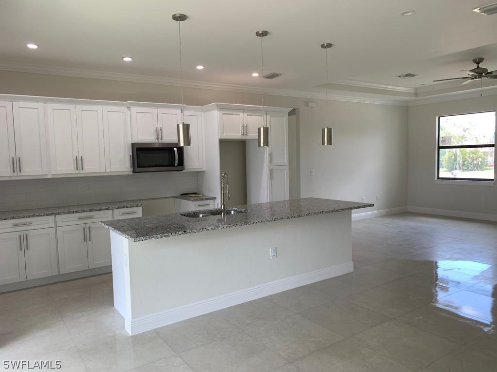 7337 Lobelia Road Fort Myers, FL 33967 - Photo 10 of 21 a kitchen with kitchen island granite countertop a sink cabinets and stainless steel appliances