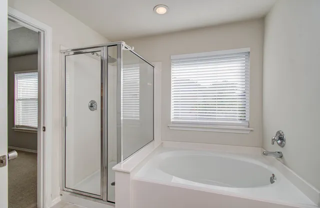 an empty room with windows and chandelier fan
