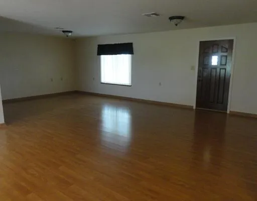an empty room with closet and windows
