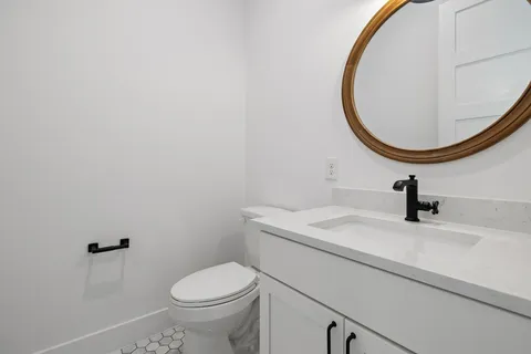 a bathroom with a sink a toilet and a mirror