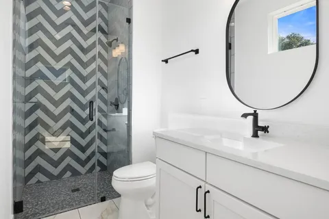 a bathroom with a sink a toilet and a mirror