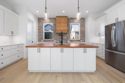 a kitchen with kitchen island white cabinets and refrigerator