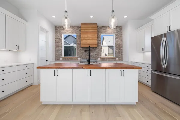 a kitchen with kitchen island white cabinets and refrigerator