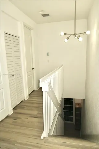 a view of a hallway with wooden floor and staircase