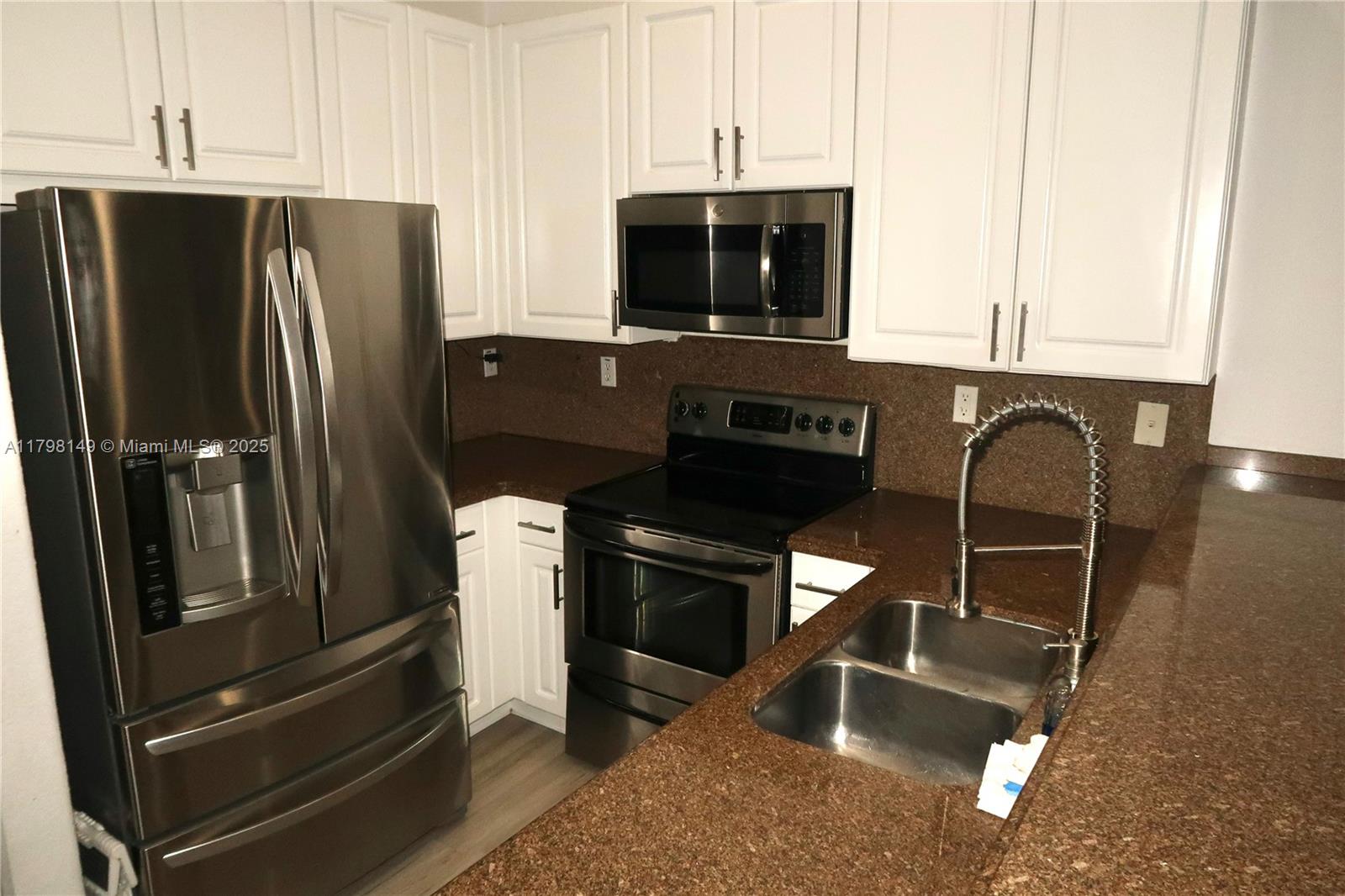 531 Southwest 147th Avenue, Unit 24 Pembroke Pines, FL 33027 - Photo 5 of 16 a kitchen with stainless steel appliances granite countertop a refrigerator and a stove top oven