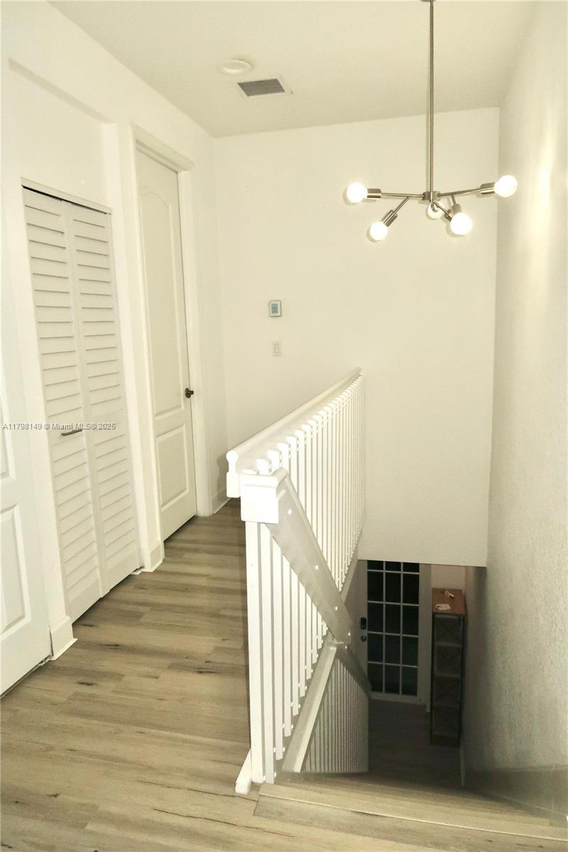 531 Southwest 147th Avenue, Unit 24 Pembroke Pines, FL 33027 - Photo 10 of 16 a view of a hallway with wooden floor and staircase