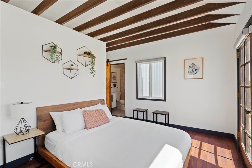 66750 Pole Line Road Joshua Tree, CA 92252 - Photo 15 of 36 a bedroom with a bed and painting on the wall