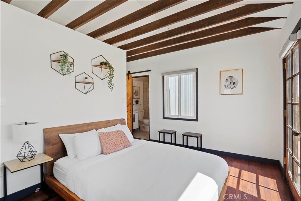 66750 Pole Line Road Joshua Tree, CA 92252 - Photo 15 of 36 a bedroom with a bed and painting on the wall