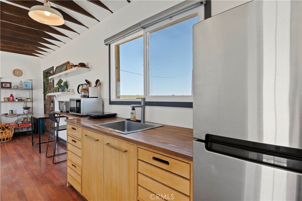 66750 Pole Line Road Joshua Tree, CA 92252 - Photo 18 of 36 a kitchen with sink cabinets and wooden floor