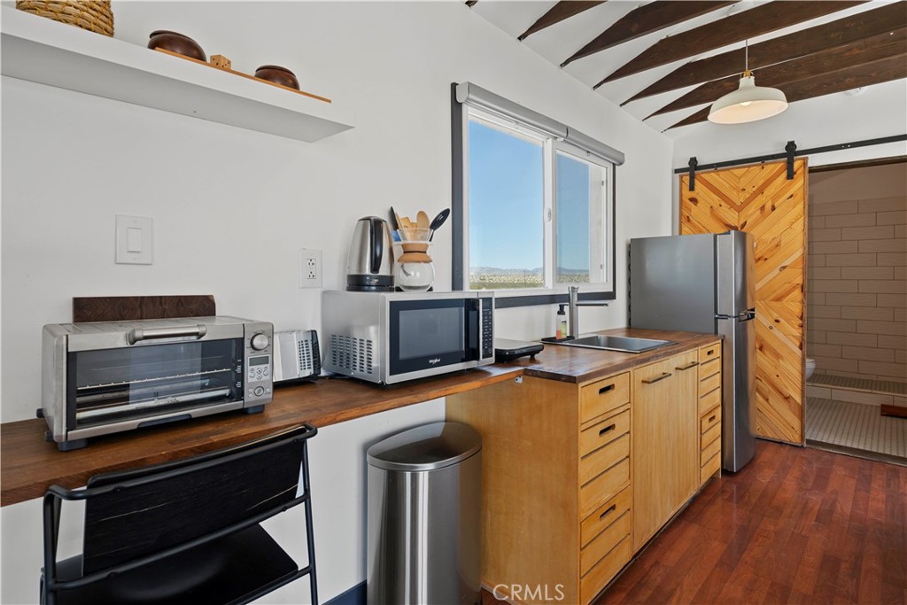 66750 Pole Line Road Joshua Tree, CA 92252 - Photo 20 of 36 a kitchen with stainless steel appliances a stove microwave and refrigerator