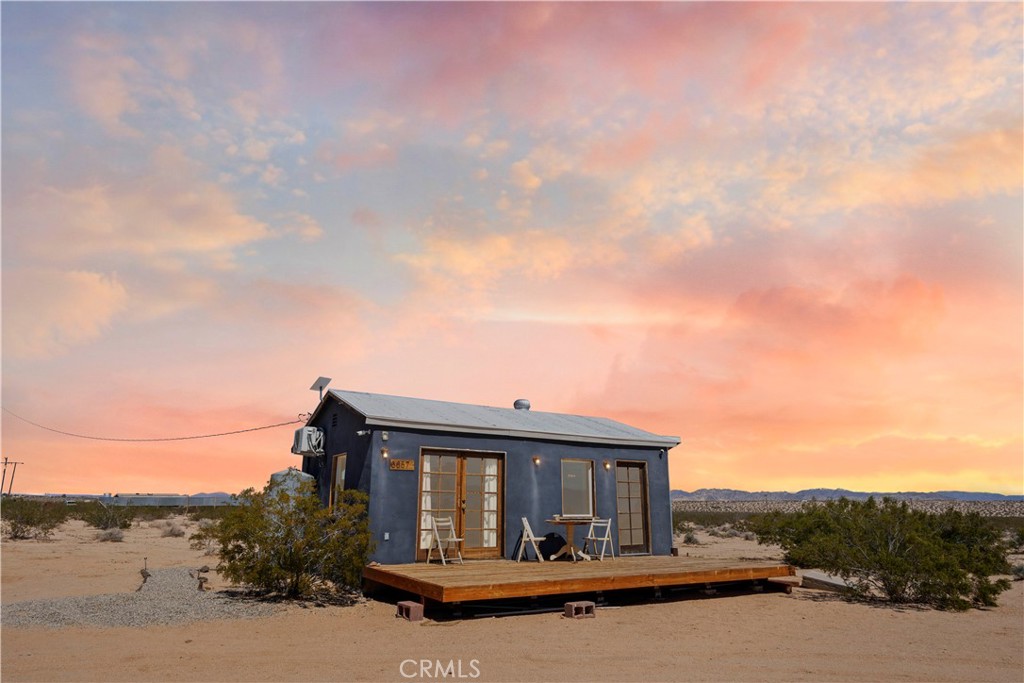 66750 Pole Line Road Joshua Tree, CA 92252 - Photo 2 of 36 a front view of house with yard space and trees around