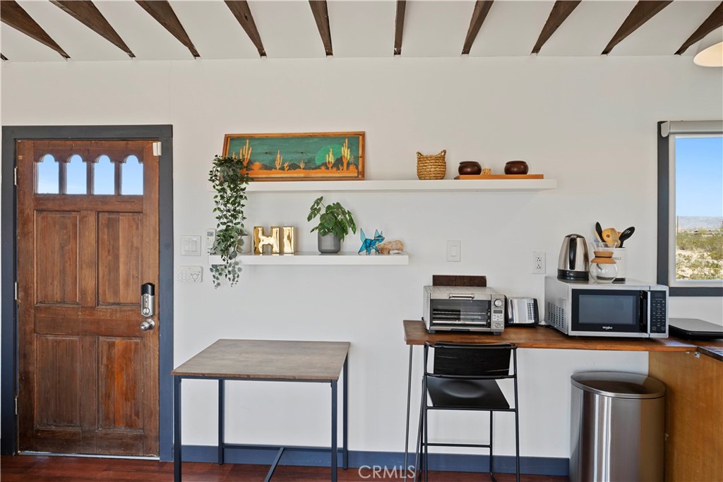 66750 Pole Line Road Joshua Tree, CA 92252 - Photo 21 of 36 a kitchen with stainless steel appliances a stove and a refrigerator with wooden floor