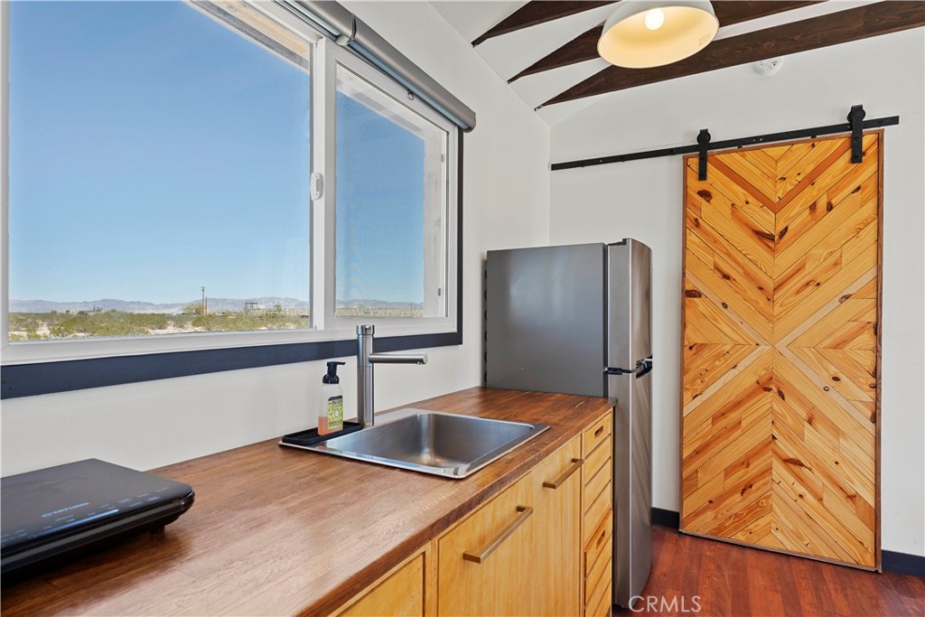 66750 Pole Line Road Joshua Tree, CA 92252 - Photo 25 of 36 a kitchen with stainless steel appliances granite countertop a sink and a refrigerator